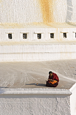 Tibetan Buddhist monk reading scriptures at the Boudha stupa at Bodhanath, Kathmandu, Nepal, Asia