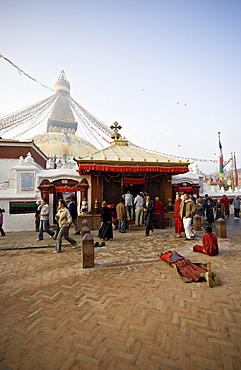 A Buddhist prostrates at dawn before the main entrance to Kathmandu's Tibetan stupa called Boudha (Boudhanath) (Bodhnath), Kathmandu, UNESCO World Heritage Site, Nepal, Asia