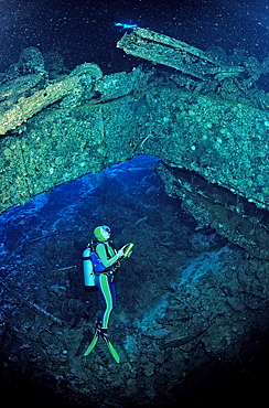 Scuba diver and truck wreck in Blue Belt shipwreck, Sudan, Red Sea, Africa