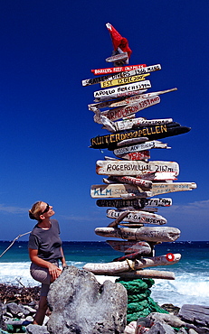 Tourist and Signpost on the beach, Netherlands Antilles, Bonaire, Caribbean Sea