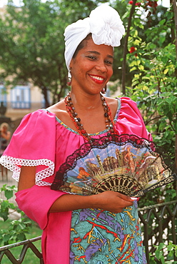 Beautiful young lady in traditional Cuban colonial garment with scarf and Spanish fan, Habana Vieja, Havana, Cuba