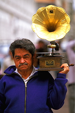 Cuenca World Heritage City & Ecuador's third largest city, famous for its colonial architecture man carrying a gramophone on street, Highlands, Ecuador