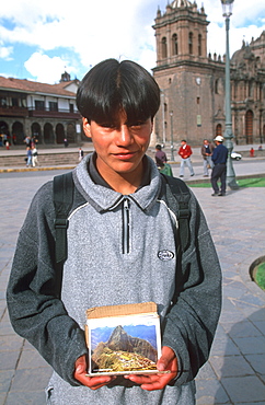 Ancient capital of the Incas the Plaza de Armas with a young boy selling postcards, Cuzco, Highlands, Peru