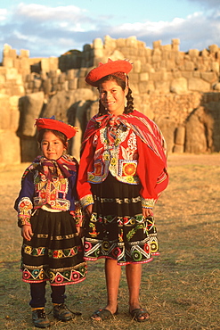 Sacsayhuaman huge hilltop, Inca fortress built in the 15thC above Cuzco with walls of immense stones children below walls, Highlands, Peru