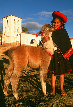 Chincheros an ancient village near Cuzco its colonial church is built on Inca foundations young Indian girl and pet llama in main plaza, Highlands, Peru