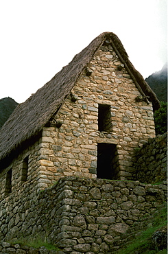 Machu Picchu a house showing construction details, especially stone protuberances used for tying down thatch roofs, Highlands, Peru