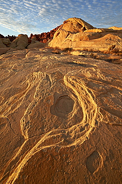 Erosion pattern in yellow sandstone under patterned clouds, Valley of Fire State Park, Nevada, United States of America, North America