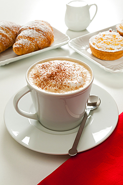 Cappuccino with croissant and rice puddings (budini di riso), Italy, Europe