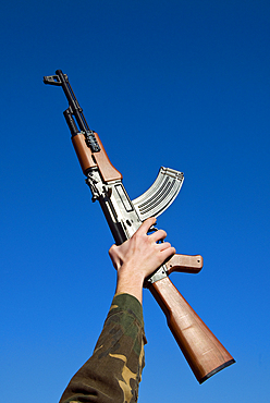 Young man holding a Kalashnikov rifle (AK47), Florence, Tuscany, Italy, Europe