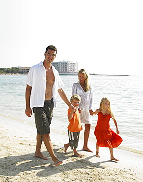 Parents and children (6-8) walking on beach