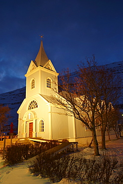 Traditional wooden church at night, built in 1922, at Seydisfjordur, a town founded in 1895 by a Norwegian fishing company, now main ferry port to and from Europe in the East Fjords, Iceland, Polar Regions