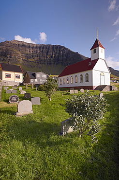 Church and village of Kunoy, located on the west coast of the island Kunoy, impressively surrounded by high mountains, Kunoy island, Nordoyar, Faroe Islands (Faroes), Denmark, Europe