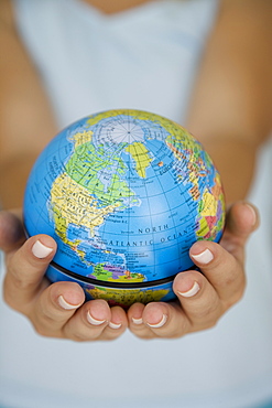 Woman's hands holding world globe