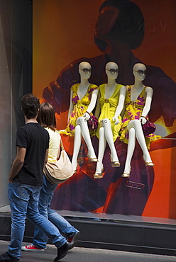 Couple looking at mannequin display in fashion shop, Milan, Lombardy, Italy, Europe