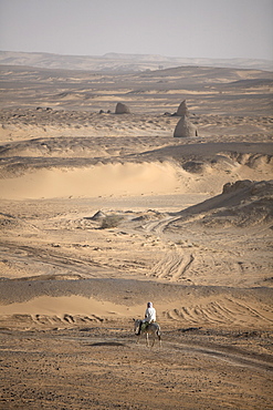 A man on mule-back traverses the desert around the ancient city of Old Dongola, Sudan, Africa