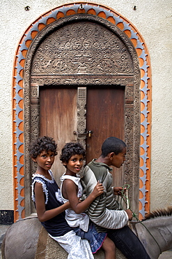 Children in front of a Lamu door, Lamu Town, Lamu, Kenya, East Africa, Africa