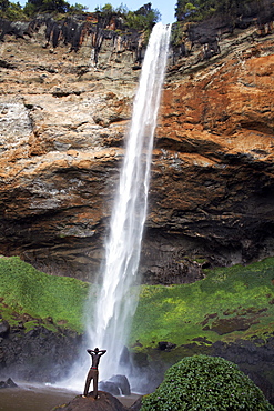 A man looks up at Sipi Falls, Uganda, East Africa, Africa