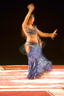 Belly dancer performing a traditional dance in the open air at night, near Abu Dhabi, United Arab Emirates, Middle East