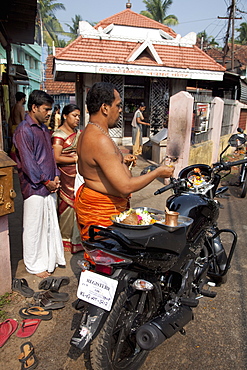 Priest blessing a new motorcycle outside a temple in Kochi (Cochin), Kerala, India, Asia 