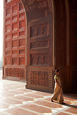 Indian lady in traditional dress walking into the mosque of the Taj Mahal, Agra, Uttar Pradesh, India, Asia