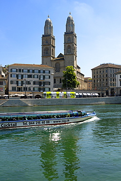 Sightseeing boat on the River Limmat in front of Grossmunster church, Zurich, Switzerland, Europe