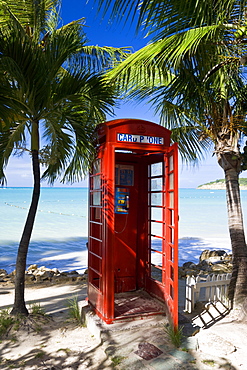 Traditional English red telephone box on the beach at Dickenson Bay, Antigua, Leeward Islands, West Indies, Caribbean, Central America