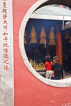 The A Ma Temple, incense hangs from the ceiling as worshippers pray and make offerings, Macau, China, Asia