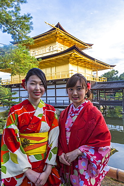 Women in traditional Japanese kimonos in front of the Golden Pavilion temple (Kinkaku-ji) in Kyoto, Japan, Asia