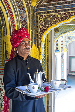 Waiter carrying tea tray in ornate passageway, Samode Palace, Jaipur, Rajasthan, India, Asia