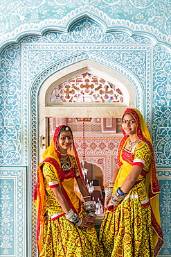 Ladies wearing colourful saris in ornate passageway, Samode Palace, Jaipur, Rajasthan, India, Asia