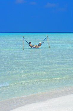 Couple relaxing in hammock, Maldives, Indian Ocean, Asia