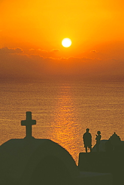 Church and couple silhouetted at sunset, Santorini, Cyclades, Greek Islands, Greece, Europe