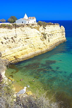 Church on cliff by beach, Algarve, Portugal, Europe