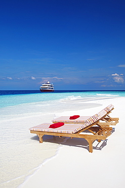 Lounge chairs on beach and yacht, Maldives, Indian Ocean, Asia