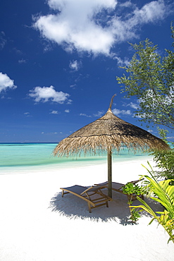 Lounge chairs under shade of umbrella on tropical beach, Maldives, Indian Ocean, Asia