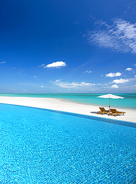 infinity pool and sun loungers on a tropical beach, Maldives,