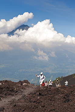 Climbing Pacaya volcano, with Fuego Volcano in distance, Antigua, Guatemala, Central America