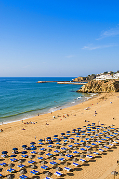 Cliffside, beachgoers and umbrellas at Praia dos Pescadores or Fishermans Beach, Albufeira, faro district, algarve, portugal, europe.