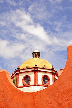 Mexico, Bajio, San Miguel de Allende, Dome of the Parroquia church part framed by orange painted wall.