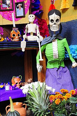 Mexico, Michoacan, Patzcuaro, Dia de los Muertos Day of the Dead altar with skeleton figures flowers and colourful paper decorations.