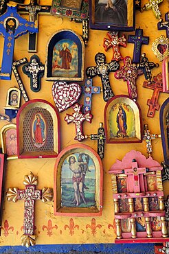 Mexico, Michoacan, Patzcuaro, Religious kitsch art displayed on yellow painted wall.