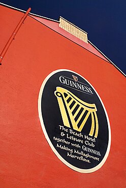 Ireland, County Sligo, Mullaghmore, Advert for Guinness on red wall of the beach hotel.