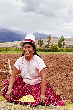 Peru, Chinchero, Peruvian female farmer showing the corn that she is planting.