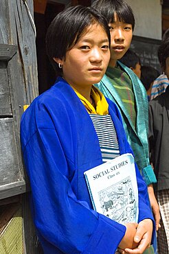 Bhutan, Mongar, Portrait of a Bhutanese school girl holding Social Studies textbook.