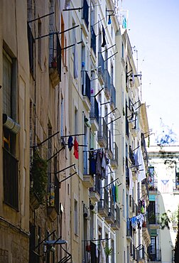 Spain, Catalonia, Barcelona, Washing hanging from windows of an apartment building in the Gothic Quarter district.