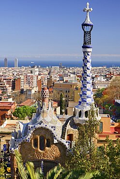 Spain, Catalunya, Barcelona, Parc Guell by Antoni Gaudi, the Administration Lodge at the park's entrance with the city and sea in the background.