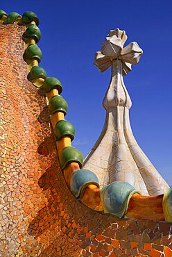 Spain, Catalunya, Barcelona, Antoni Gaudi's Casa Batllo building, dragon's back feature on the roof terrace with the four armed cross also inclluded.