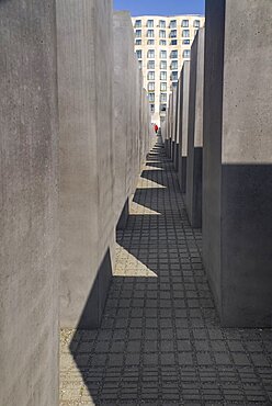 Germany, Berlin, A tourist walking through The Memorial to the Murdered Jews of Europe more commonly known as the Holocaust Memorial.