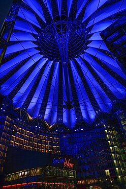 Germany, Berlin, Potzdamer Platz, Sony Centre with glass canopied roof over central plaza at night.