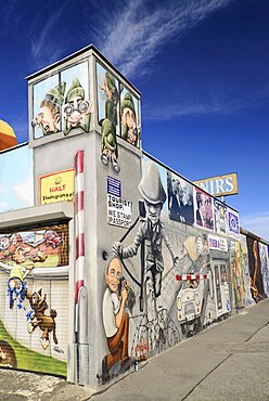 Germany, Berlin, The East Side Gallery, a 1.3 km long section of the Berlin Wall, Wall paintings and signs advertising Souvenirs and Tourist Shop.